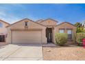 Tan single-story home with a two-car garage, desert landscaping and some greenery under a blue sky at 1541 W Lynne Ln, Phoenix, AZ 85041