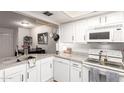 Bright kitchen featuring white cabinets, granite countertops, and modern appliances at 1645 W Baseline Rd # 2176, Mesa, AZ 85202