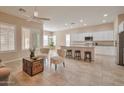 Open-concept living space with kitchen, breakfast bar, living room, neutral decor and tile flooring at 16955 W Cypress St, Goodyear, AZ 85395