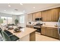Well-lit kitchen boasting a large island, stainless steel appliances, and a view to the outside at 17341 W Fallen Leaf Ln, Surprise, AZ 85387