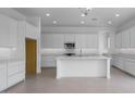 Bright, spacious kitchen with white cabinets, stainless steel appliances, a central island, and sleek countertops at 17827 W Medlock Dr, Litchfield Park, AZ 85340