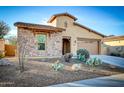 Attractive home with a stone facade, desert landscaping, and a two-car garage at 18107 W Thunderhill Pl, Goodyear, AZ 85338