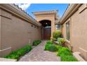 Inviting front entryway with a brick path, lush greenery, and a charming bench leading to the front door at 2452 W Enfield Way, Chandler, AZ 85286