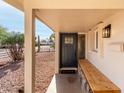 Cozy covered front porch with a wooden bench and charming welcome mat at 3632 E Poinsettia Dr, Phoenix, AZ 85028