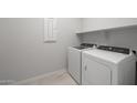 Bright laundry room with new white washer and dryer, complemented by built-in shelving at 4113 S 176Th Dr, Goodyear, AZ 85338