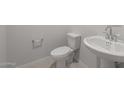 Powder room featuring classic pedestal sink and toilet against neutral walls at 4113 S 176Th Dr, Goodyear, AZ 85338