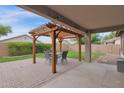 Backyard patio with brick pavers, a pergola, and a dining table creates a charming outdoor seating area at 4364 S Tatum Ln, Gilbert, AZ 85297