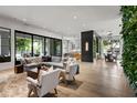 Open-concept living room with hardwood floors, large windows, stylish furniture, and views of the kitchen at 4901 E Lafayette Blvd, Phoenix, AZ 85018