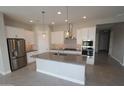 Modern kitchen featuring a center island, stainless steel appliances, and white cabinetry at 5619 N 193Rd Ave, Litchfield Park, AZ 85340