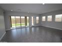 Bright living room with tile flooring, large sliding glass doors, and multiple windows at 5619 N 193Rd Ave, Litchfield Park, AZ 85340