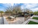 Outdoor dining area with stone columns and lush desert landscaping perfect for entertaining at 6009 E Dale Ln, Cave Creek, AZ 85331