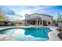 Sparkling blue pool with a travertine deck and lush desert landscaping in the backyard at 6009 E Dale Ln, Cave Creek, AZ 85331