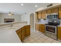 Bright kitchen with wooden cabinets, stainless steel appliances, and tiled flooring at 7009 W Taro Ln, Glendale, AZ 85308