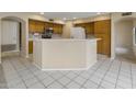 Spacious kitchen with wooden cabinetry, a breakfast bar, and white tile flooring at 7009 W Taro Ln, Glendale, AZ 85308