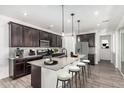 Spacious kitchen featuring dark cabinets, a center island, and stainless steel appliances, ideal for cooking at 7138 W Kent Dr, Chandler, AZ 85226