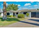 Attractive single-story home with lush landscaping and a contemporary garage door at 8319 E Indianola Ave, Scottsdale, AZ 85251