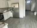 Open concept kitchen with white cabinets, stainless steel appliances and stylish tile flooring at 8349 W Holly St, Phoenix, AZ 85037
