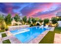 Inviting pool with waterfall feature, lush landscaping, and modern white lounge chairs at 851 E Deer Creek Rd, Phoenix, AZ 85048
