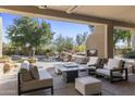 Relaxing covered patio with outdoor fireplace, offering views of the pool and landscaped backyard at 10040 E Happy Valley Rd # 479, Scottsdale, AZ 85255