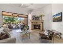 Elegant living room with a stone fireplace and seamless indoor-outdoor flow to a covered patio at 10040 E Happy Valley Rd # 479, Scottsdale, AZ 85255