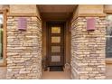 Inviting front entrance with decorative stone accents and stylish modern lighting fixtures at 10260 E White Feather Ln # 1022, Scottsdale, AZ 85262
