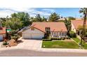 Inviting home with a terracotta roof, a three-car garage, manicured landscaping, and a charming front lawn at 1110 N Gull Haven Ct, Gilbert, AZ 85234