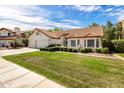 A well-maintained home showcasing traditional Southwestern architecture, lush landscaping, and a vibrant green lawn at 1110 N Gull Haven Ct, Gilbert, AZ 85234