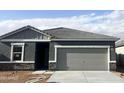 New home with gray exterior, stone accents, tile roof and a two-car garage at 13240 E Verbina Ln, Florence, AZ 85132
