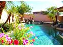 Inviting pool area featuring a rock waterfall, lush landscaping, and sparkling turquoise water at 15515 N 174Th Ave, Surprise, AZ 85388