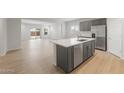 Open-concept kitchen featuring gray cabinetry, stainless steel appliances, and a center island at 17764 W Getty Dr, Goodyear, AZ 85338