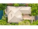 Aerial view of the house showcasing its unique roofline, lush landscaping, and serene waterfront location at 1833 W Mead Pl, Chandler, AZ 85248