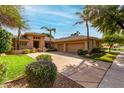 Charming single-story home with a well-manicured lawn, mature landscaping, and a spacious three-car garage at 1833 W Mead Pl, Chandler, AZ 85248