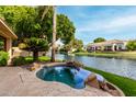 Inviting backyard pool and spa with lush landscaping and a serene waterfront view at 1833 W Mead Pl, Chandler, AZ 85248