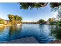 Panoramic view of the waterfront showcasing a dock, calm water, and beautiful surrounding homes at 1833 W Mead Pl, Chandler, AZ 85248