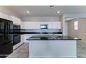 Spacious kitchen with white cabinets, granite countertops, stainless steel appliances, and a large center island at 25755 W Hazel Dr, Buckeye, AZ 85326