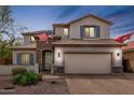 Charming two-story home with a manicured lawn and attached two-car garage at dusk at 2605 W Golden Puma Trl, Phoenix, AZ 85085