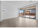 An open living space with wood-look tile flooring and large sliding glass doors overlooking the backyard at 26079 S 228Th St, Queen Creek, AZ 85142
