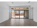 A spacious living room featuring wood-look tile flooring, large sliding glass doors, and neutral paint at 26079 S 228Th St, Queen Creek, AZ 85142