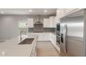 Modern kitchen featuring white cabinets, stainless steel appliances, and a stylish gray backsplash at 4119 S 176Th Dr, Goodyear, AZ 85338