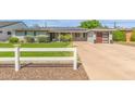 Charming single-story home with a well-manicured lawn, updated garage door, and solar panels at 4208 E Windsor Ave, Phoenix, AZ 85008
