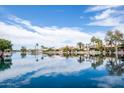 Beautiful calm lake view reflecting blue sky and clouds with luxury home in distance at 665 W Beechnut Dr, Chandler, AZ 85248