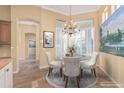 Bright breakfast nook features elegant chandelier, round glass table, and white plantation shutters at 7538 E Tuckey Ln, Scottsdale, AZ 85250