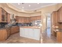 Spacious kitchen with custom cabinets, an island, stainless steel appliances, and travertine flooring at 7538 E Tuckey Ln, Scottsdale, AZ 85250