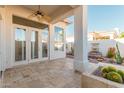 Covered patio with ceiling fan, travertine flooring, and view of private yard with fountain at 7538 E Tuckey Ln, Scottsdale, AZ 85250