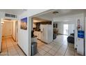 Hallway with access to the kitchen, dining area, and bedrooms, complemented by tile flooring at 811 E Seldon Ln, Phoenix, AZ 85020