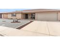 Wide view of the home from the street, showing its two-car garage and low-maintenance desert landscaping at 8315 E Lobo Ave, Mesa, AZ 85209