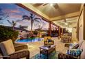 Relaxing covered patio features comfortable seating, ceiling fans, and a view of the pool with rock waterfall at 911 E Desert Inn Dr, Chandler, AZ 85249