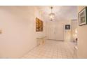 Bright foyer with tiled floor, chandelier, console table, artwork and double door entry at 932 S Pico Cir, Mesa, AZ 85206