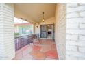 Inviting front porch with tiled floor, bench, security gate and charming exterior lighting at 932 S Pico Cir, Mesa, AZ 85206