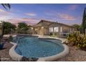 Backyard pool with waterfall feature, patio, and mature landscaping, perfect for outdoor living at 9733 W Hedge Hog Pl, Peoria, AZ 85383